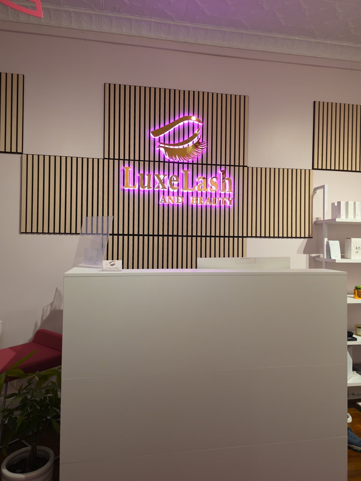 LuxeLash And Beauty front desk with illuminated logo